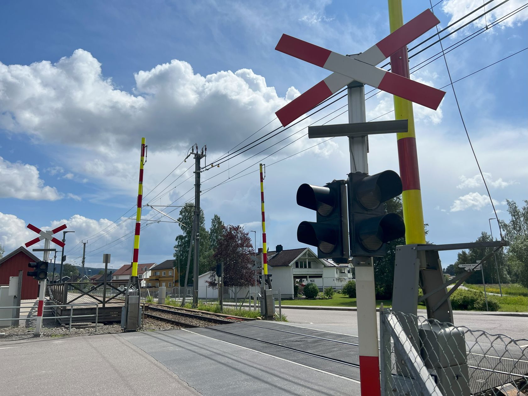 Planovergang på jernbanen. Bommene er oppe.