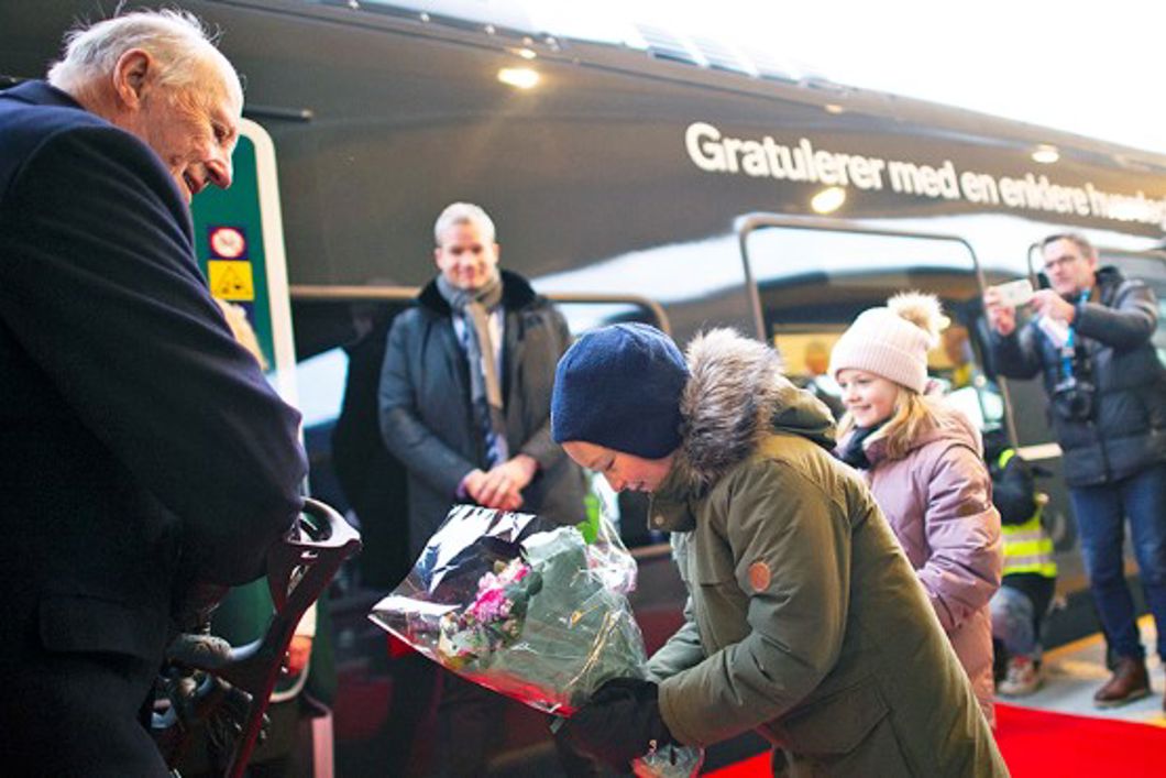 Bilde av en liten gutt som bukker og gir Hans Majestet Kong Harald en blomsterbukett.