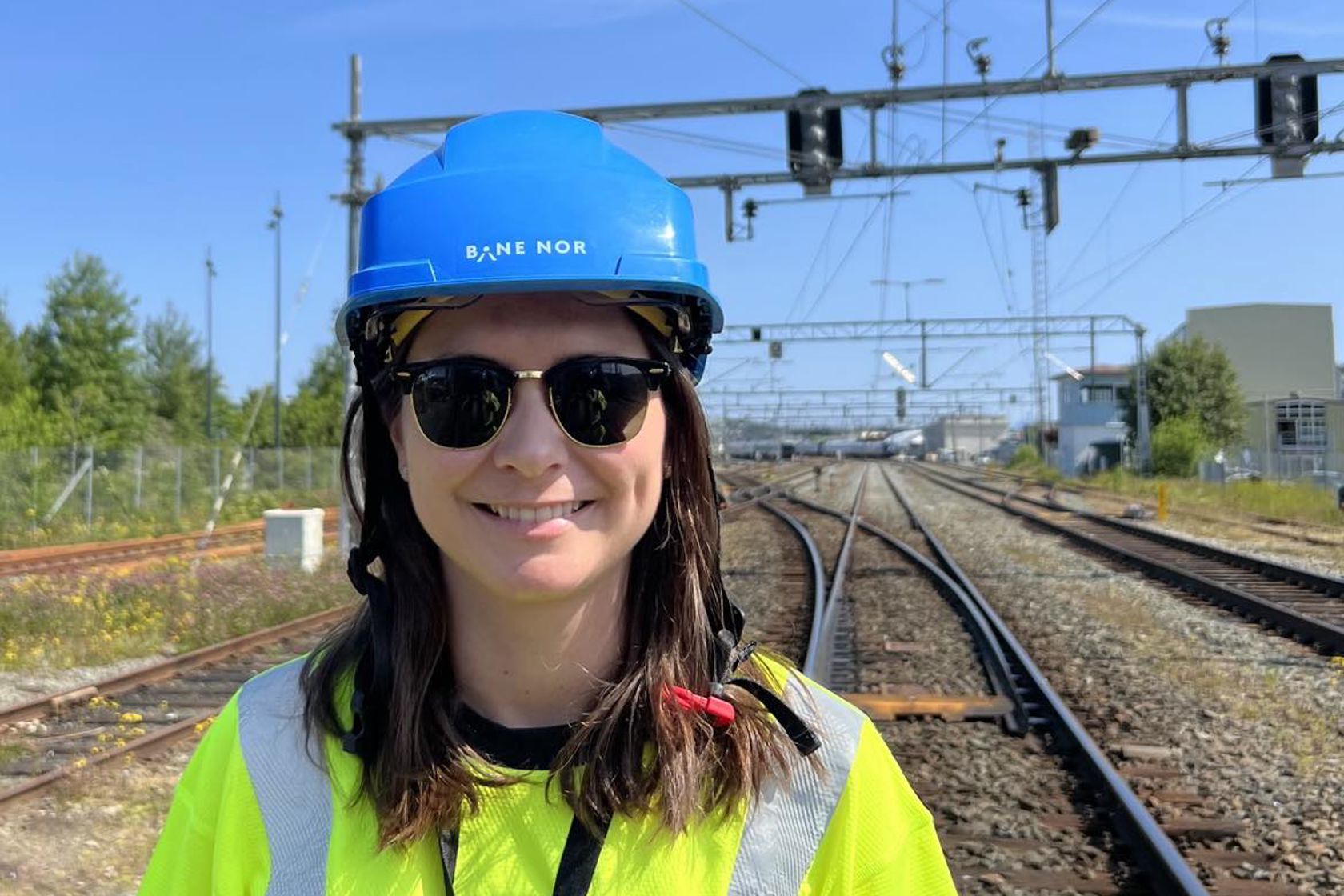 Portrettbilde av Trine Singelstad Andersen som står i vernetøy uti sporet. 