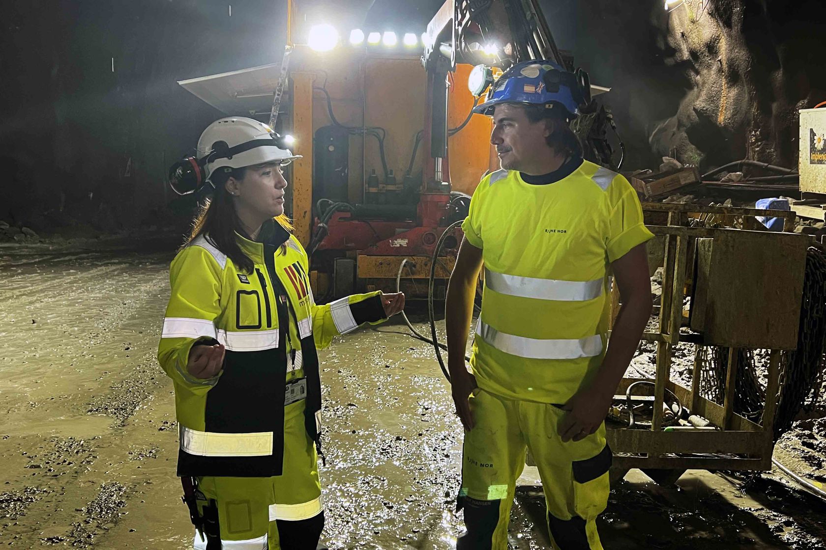 Mann og kvinne i vernetøy snakker sammen i tunnel.