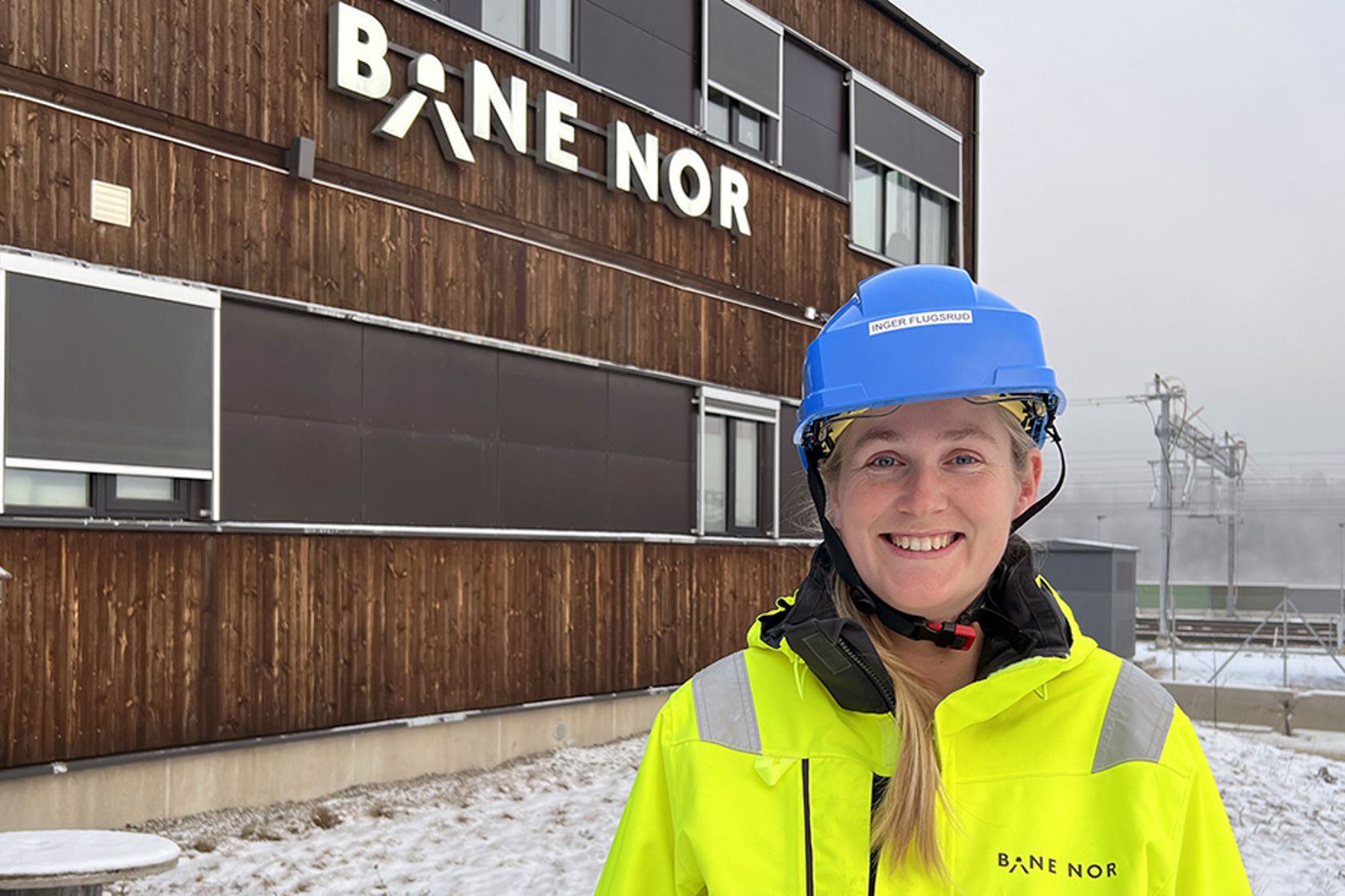 Inger med hjelm og vernetøy foran Bane NORs brakkerigg på Eidsvoll.