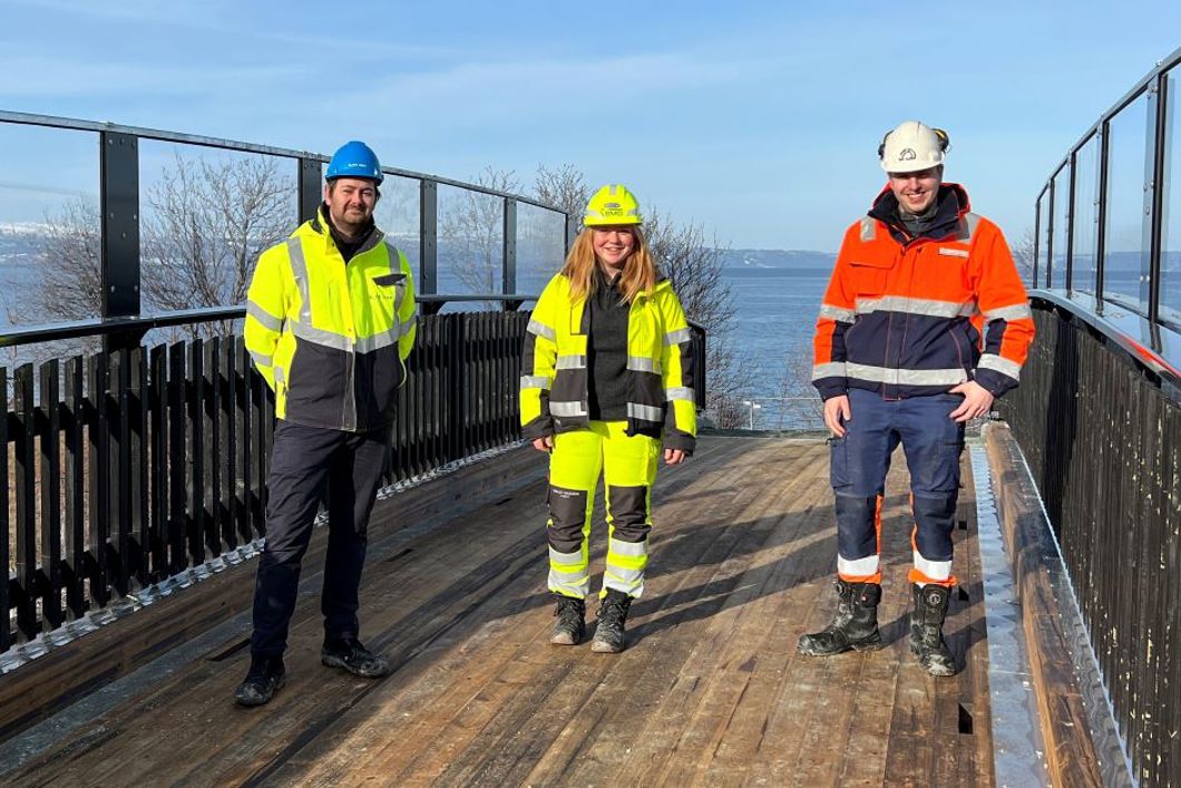 Bildet viser den nye overgangsbrua som er klar for gående passering selv om noen arbeider gjenstår. Delprosjektleder Stig Rune Bergly fra elektrifiseringsprosjektet i Bane NOR, prosjektleder for BMO Entreprenør Stina Gjøen Simensen og Magne Skrøvseth, som er anleggsleder for Farbu & Gausen er avbildet. 