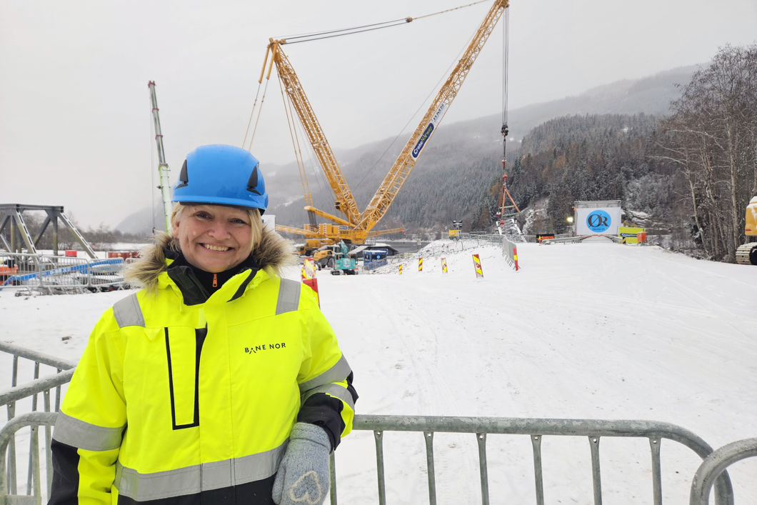 Foto av utbyggingsdirektør Bettina Sandvin ved Randklev bru, med megakrana i bakgrunnen. 